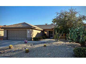 Single-story home with a two-car garage and drought-tolerant landscaping at 17561 N Saddle Ridge Dr, Surprise, AZ 85374
