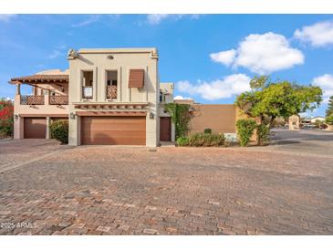 Stunning two-story home featuring a private garage, desert landscaping, and unique architecture under a bright blue sky at 6411 S River Dr # 10, Tempe, AZ 85283