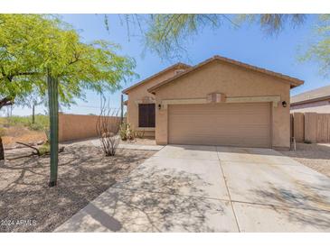 Tan house with a two-car garage and desert landscaping at 6416 E Hacienda La Noria Ln, Gold Canyon, AZ 85118