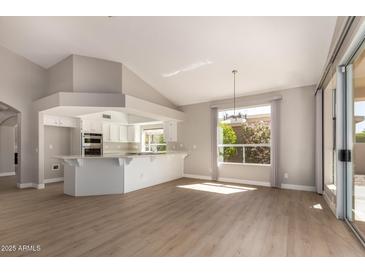 Open concept kitchen with white cabinets, stainless steel appliances, and ample counter space at 10417 E Champagne Dr, Sun Lakes, AZ 85248