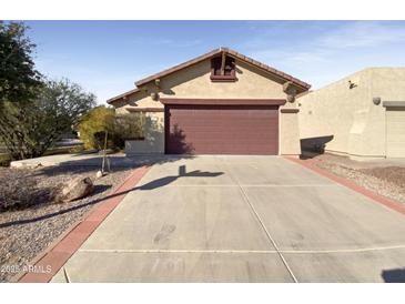 House exterior with a two-car garage and a well-maintained front yard at 10958 E Secret Mine Ct, Gold Canyon, AZ 85118