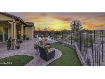 Covered patio, firepit, and artificial turf at 12128 W Desert Mirage Dr, Peoria, AZ 85383