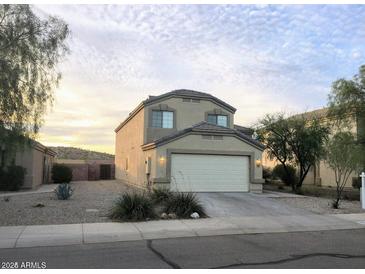 Tan two-story house with a two-car garage and landscaped front yard at 24848 N Good Pasture Ln, Florence, AZ 85132