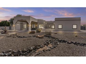 Stunning home exterior with desert landscaping, fountain, and porte cochere at 9437 W Avenida Del Sol Ave, Peoria, AZ 85383