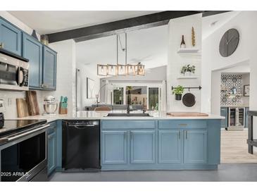 Modern kitchen with blue cabinets, quartz countertops, and stainless steel appliances at 10103 E Olla Ave, Mesa, AZ 85212