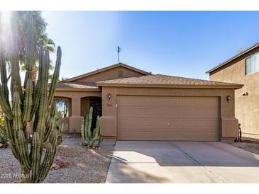 Tan house with a two-car garage and desert landscaping at 1133 E Dust Devil Dr, San Tan Valley, AZ 85143