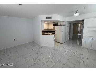 Bright living room and kitchen featuring white cabinetry and marble floors at 12221 W Bell Rd # 363, Surprise, AZ 85378