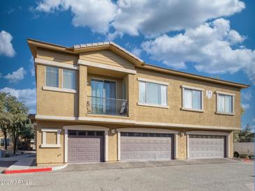 Tan two-story building with private balconies and attached garages at 15240 N 142Nd Ave # 2159, Surprise, AZ 85379