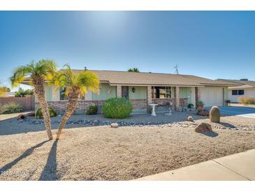 Charming ranch home with desert landscaping and two palm trees at 15489 N Ridgeview Rd, Sun City, AZ 85351