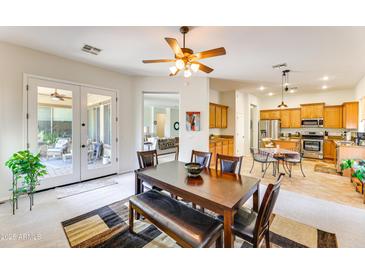 Bright dining room with wood table and access to the kitchen and backyard at 18187 W Wind Song Ave, Goodyear, AZ 85338