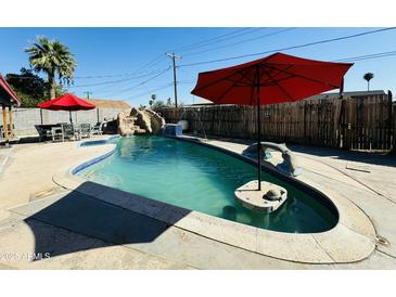 Inviting kidney-shaped pool with waterfall feature, perfect for relaxation at 3125 W Mclellan Blvd, Phoenix, AZ 85017