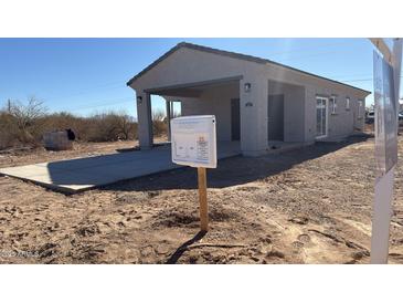 New single-story home with a covered entrance and gray stucco, situated in a desert landscape at 3205 W Sueno Dr, Eloy, AZ 85131