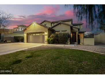 Two-story house with a three-car garage, landscaping, and a large driveway at 4332 E Vallejo Ct, Gilbert, AZ 85298