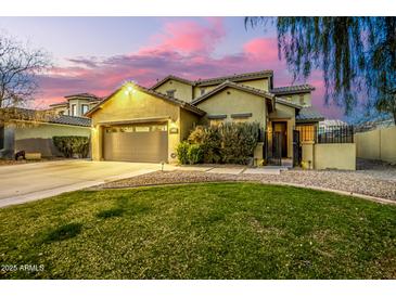 Charming two-story home with well-manicured front yard and desert landscaping at dusk at 4332 E Vallejo Ct, Gilbert, AZ 85298