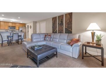 Open living area showcasing a contemporary sectional sofa and adjacent dining area at 4704 E Paradise Village N Pkwy # 239, Phoenix, AZ 85032