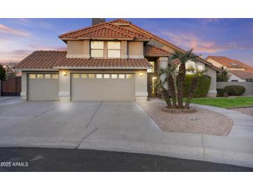 Charming two-story home featuring a three-car garage, red tile roof, and mature landscaping at 7804 W Pershing Ave, Peoria, AZ 85381