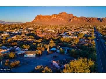 Aerial view of a property showcasing two houses, a vast landscape, and mountain views at 831 N Arroya Rd, Apache Junction, AZ 85119