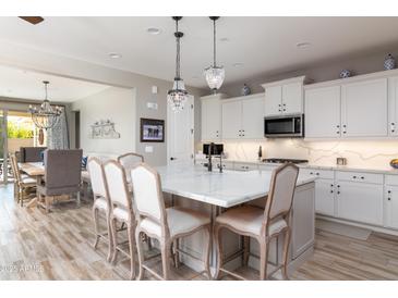 Spacious kitchen with island, stainless steel appliances, and white cabinetry at 10317 E Tillman Ave, Mesa, AZ 85212