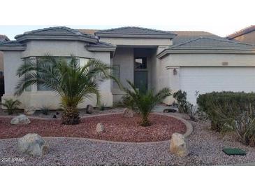 Single-story home with attractive landscaping and a two-car garage at 12930 W Pershing St, El Mirage, AZ 85335