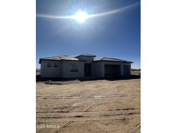 New single-story home with a two-car garage, under construction in sunny weather at 25519 W Brookhart Way, Wittmann, AZ 85361