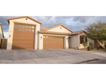 Two-car garage, light-colored brick exterior, and a well-maintained front yard at 3907 S 78Th Ln, Phoenix, AZ 85043