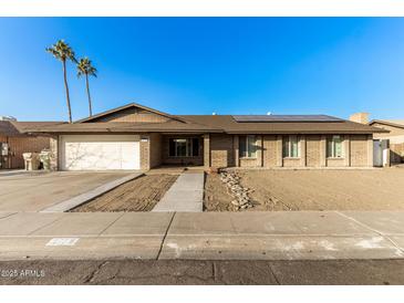 Single-story home with solar panels and a spacious front yard at 5732 W Purdue Ave, Glendale, AZ 85302