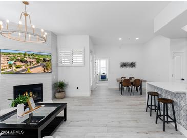 Bright living room with fireplace, TV, and hardwood floors at 7027 N Scottsdale Rd # 225, Paradise Valley, AZ 85253