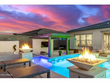 Lush backyard with a large pool and fire pits at 10712 E Trillium Ave, Mesa, AZ 85212