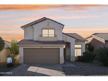 Two-story house with tan exterior and a two-car garage at 15857 W Yavapai St, Goodyear, AZ 85338