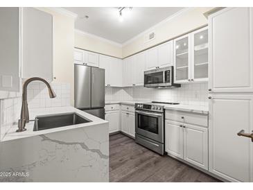 Modern kitchen features stainless steel appliances, white cabinetry, and quartz countertops at 1701 E Colter St # 223, Phoenix, AZ 85016