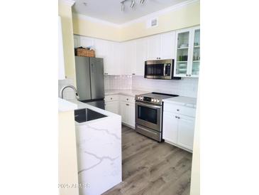 Modern kitchen with stainless steel appliances and white cabinetry at 1701 E Colter St # 223, Phoenix, AZ 85016