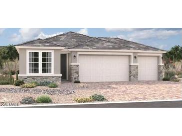 Three-car garage home with stone accents and desert landscaping at 18246 W Hess St, Goodyear, AZ 85338