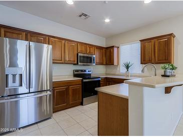 Modern kitchen featuring stainless steel appliances and wood cabinetry at 1828 W Owens Way, Anthem, AZ 85086