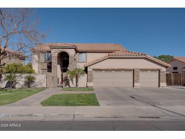 Spacious two-story home featuring a three-car garage, stone accents, and a tile roof at 2848 E Menlo St, Mesa, AZ 85213