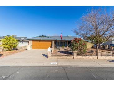 Ranch-style home with a brick facade, attached garage, and well-maintained landscaping at 5210 W Ironwood Dr, Glendale, AZ 85302