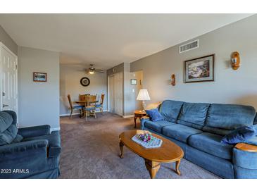 Bright living room with comfy blue couch and access to a patio at 5877 N Granite Reef Rd # 2224, Scottsdale, AZ 85250