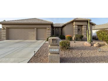 Front view of a tan house with a two-car garage and desert landscaping at 9321 E Diamond Dr, Sun Lakes, AZ 85248