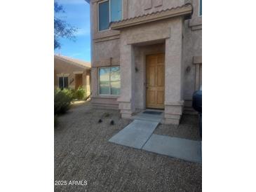 Welcoming home exterior features a light brown front door and low maintenance gravel landscaping at 1259 E Canyon Trl, San Tan Valley, AZ 85143