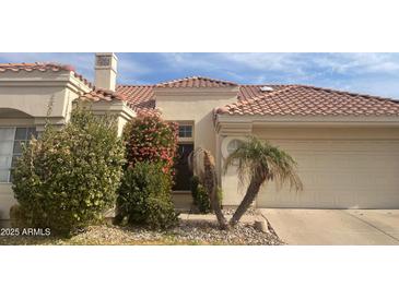 Tan two-story house with tile roof, landscaping, and two-car garage at 2127 W Peninsula Cir, Chandler, AZ 85248