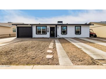 White house with black garage door and landscaping at 2317 W Danbury Rd, Phoenix, AZ 85023