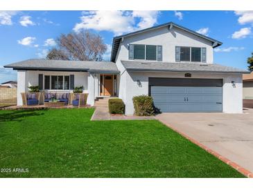 Two-story house with gray garage door and landscaped lawn at 2472 W Crocus Dr, Phoenix, AZ 85023