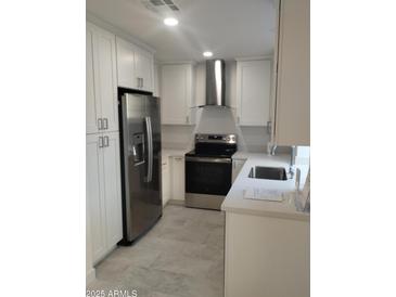 Modern kitchen featuring stainless steel appliances and white cabinetry at 2834 S Extension Rd # 1032, Mesa, AZ 85210