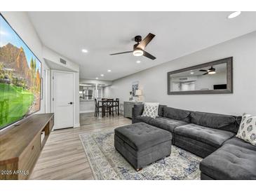 Spacious living room with L-shaped sectional sofa and large TV at 3301 E Earll Dr # 102, Phoenix, AZ 85018