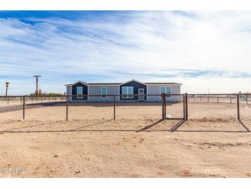 Single-story home with gray siding and a fenced yard at 36711 W Harrison St, Tonopah, AZ 85354