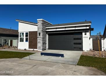 Modern home exterior with gray stone and a two-car garage at 3752 W Antelope Way, San Tan Valley, AZ 85144