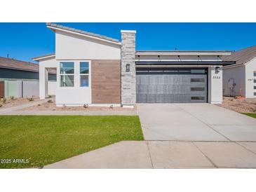 Modern home featuring a sleek, black garage door and manicured front lawn at 3752 W Antelope Way, San Tan Valley, AZ 85144