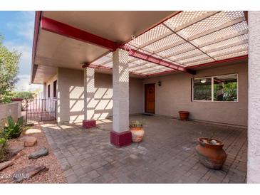 Covered patio with brick pavers, pergola, and potted plants at 5715 W Heatherbrae Dr, Phoenix, AZ 85031