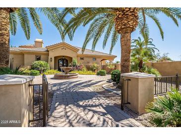 Elegant home with gated entry, fountain, and mature palm trees at 1367 S Country Club Dr # 1024, Mesa, AZ 85210