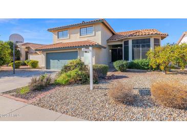 Two-story house with green garage door, landscaping, and basketball hoop at 19222 N 70Th Ave, Glendale, AZ 85308