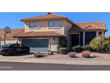 Two-story house with tile roof, attached garage, and basketball hoop at 19222 N 70Th Ave, Glendale, AZ 85308